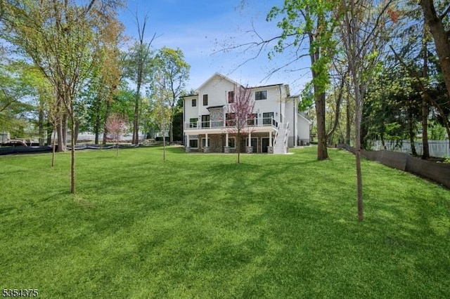 back of house featuring a lawn, fence, and stairway
