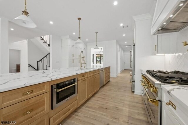 kitchen featuring custom exhaust hood, baseboards, recessed lighting, a sink, and premium appliances
