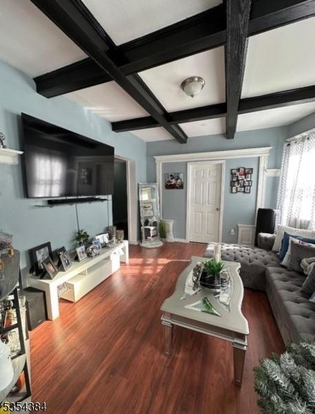 living room with wood finished floors, beamed ceiling, and coffered ceiling
