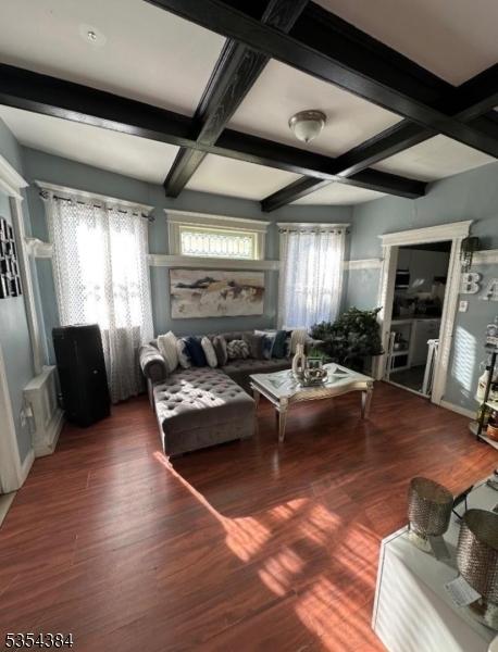 living room with coffered ceiling, wood finished floors, and beamed ceiling