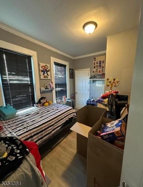 bedroom featuring wood finished floors and crown molding