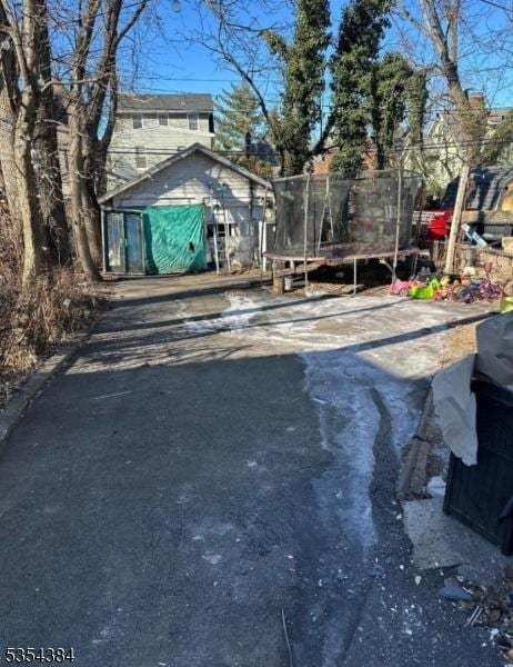 view of front of property featuring a trampoline and driveway