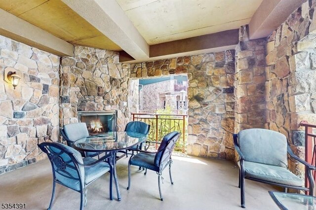 3 Wild Turkey Way Unit 240/, Hardyston Twp, NJ 07419 - dining space with finished concrete flooring, beamed ceiling, and a warm lit fireplace