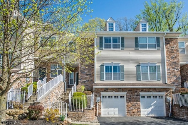 multi unit property with an attached garage and driveway