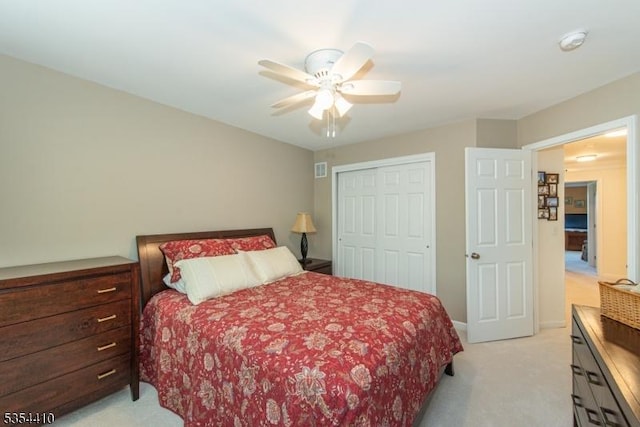 bedroom featuring a ceiling fan, baseboards, light carpet, and a closet
