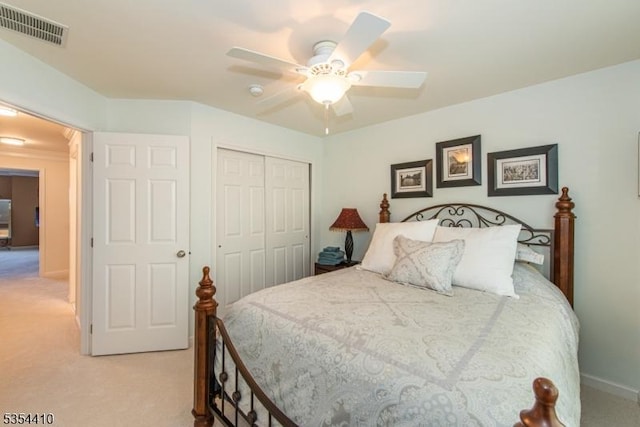 bedroom featuring light colored carpet, a ceiling fan, baseboards, visible vents, and a closet