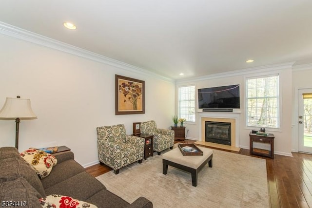 living area with a fireplace with flush hearth, ornamental molding, recessed lighting, and hardwood / wood-style floors