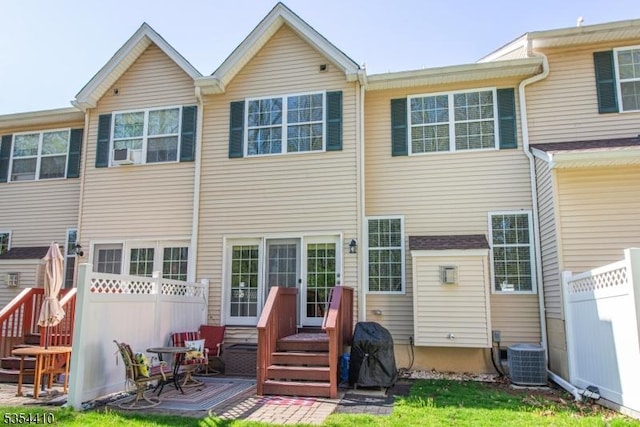 rear view of property featuring fence and cooling unit