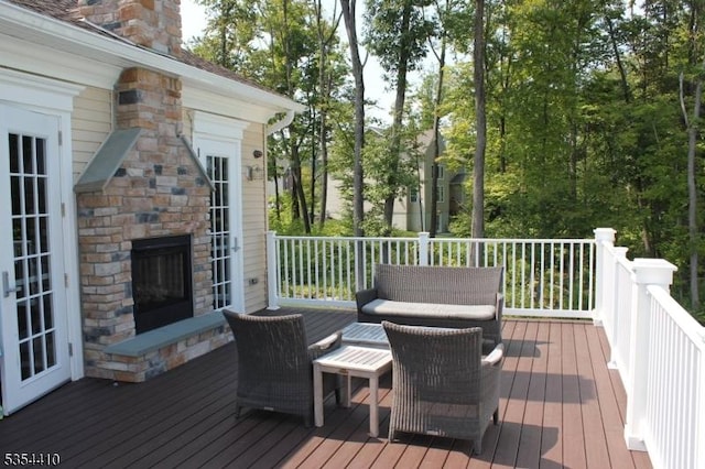 deck with an outdoor stone fireplace