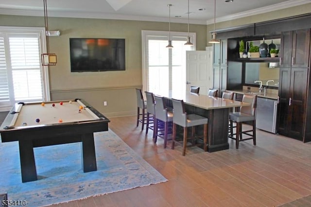 interior space with light wood-style floors, billiards, crown molding, and baseboards