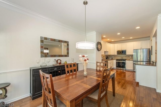 dining space with recessed lighting, ornamental molding, and dark wood-style flooring