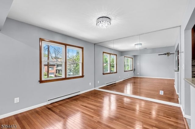 42 E Lincoln Ave, Roselle Park Boro, NJ 07204 - spare room featuring baseboard heating, a chandelier, baseboards, and hardwood / wood-style flooring