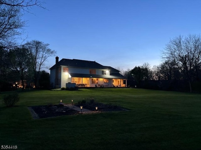 17 Hunters Path, Montgomery Twp, NJ 08558 - back of house at dusk featuring a lawn and a chimney