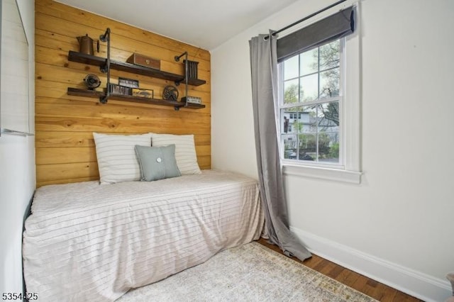 bedroom featuring baseboards and wood finished floors