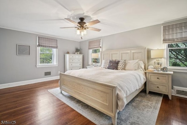 bedroom featuring multiple windows, dark wood-type flooring, and visible vents