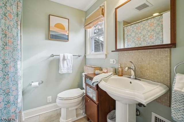 bathroom featuring visible vents, toilet, baseboards, a shower with shower curtain, and tile patterned floors