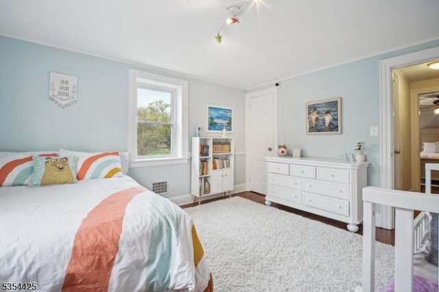 bedroom featuring visible vents, baseboards, and wood finished floors