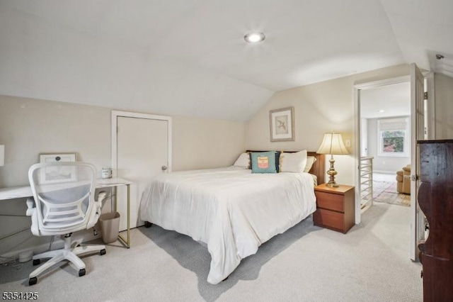 carpeted bedroom with lofted ceiling