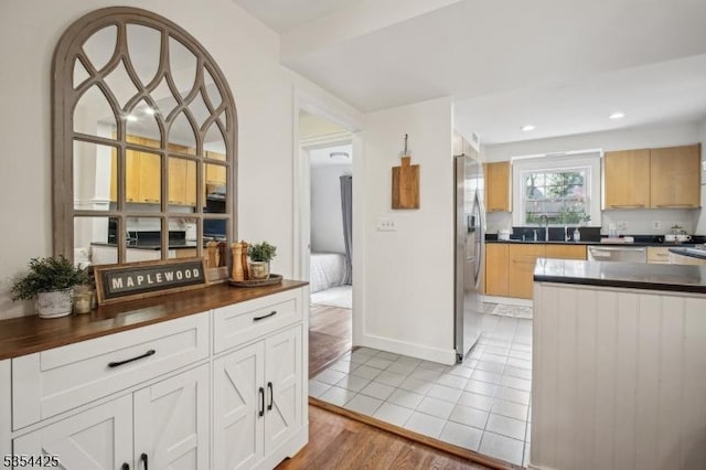 kitchen with light tile patterned flooring, dark countertops, recessed lighting, a sink, and stainless steel appliances