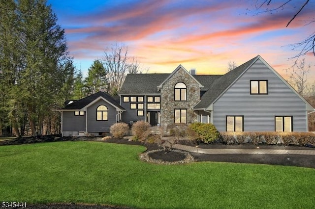 25 Hook Mountain Dr, Clinton Twp, NJ 08801 - back of house at dusk with a lawn, roof with shingles, and stone siding