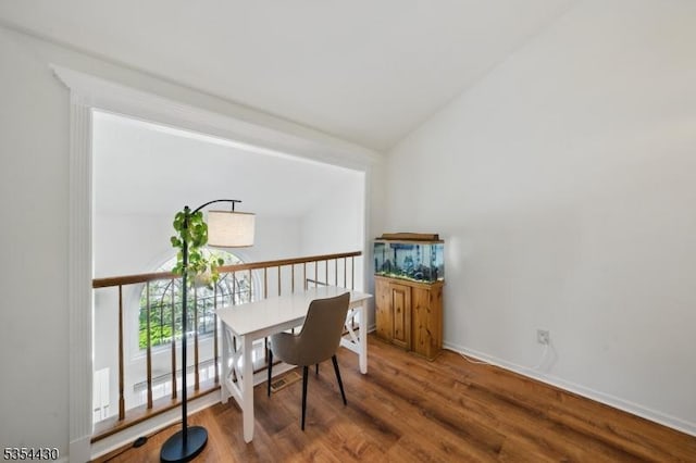interior space featuring baseboards, lofted ceiling, and wood finished floors