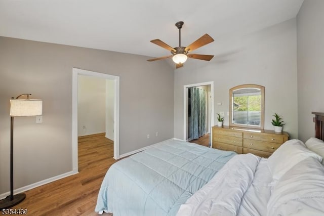 bedroom featuring baseboards, ceiling fan, wood finished floors, and lofted ceiling
