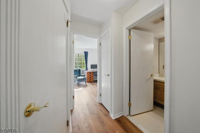 hallway featuring visible vents and light wood finished floors