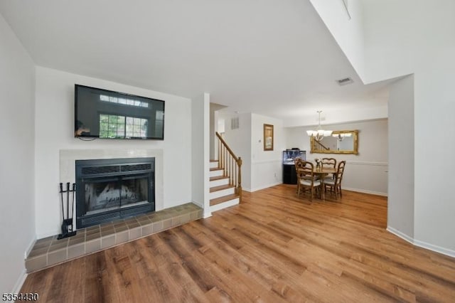 living room featuring visible vents, wood finished floors, a fireplace, and stairway