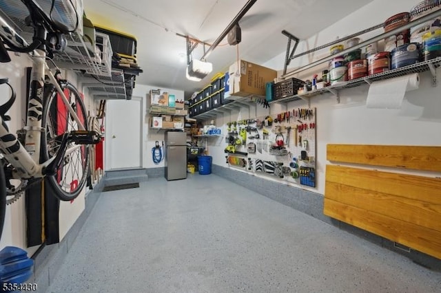 garage with freestanding refrigerator, a workshop area, and a garage door opener
