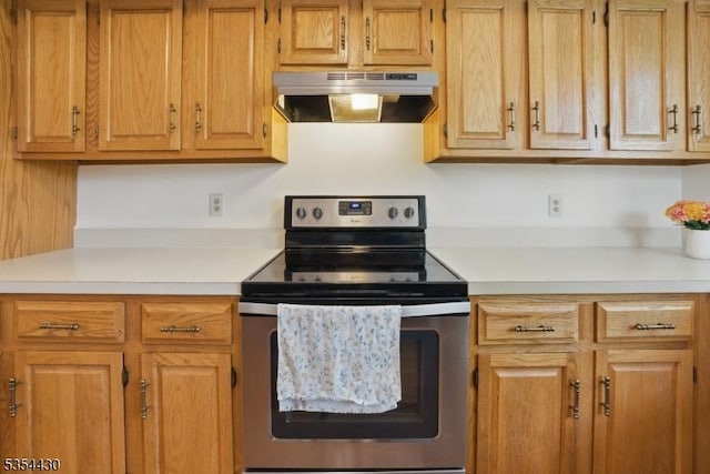 kitchen featuring light countertops, stainless steel electric range, and under cabinet range hood