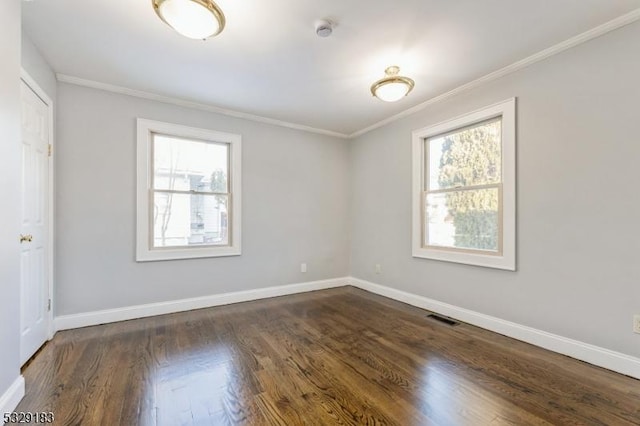 empty room featuring crown molding, baseboards, plenty of natural light, and visible vents