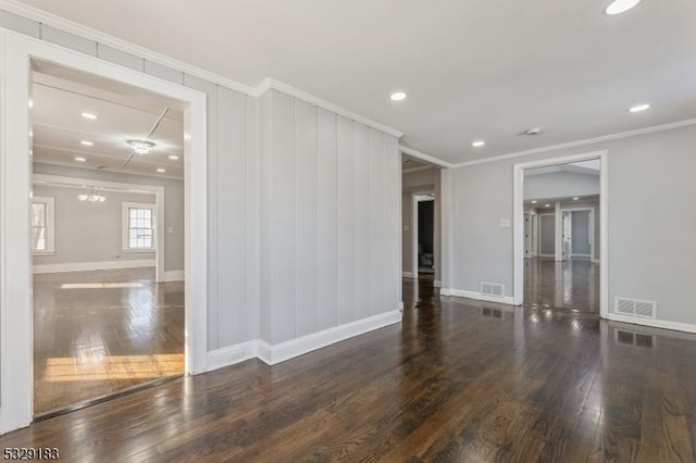 unfurnished room featuring visible vents, baseboards, crown molding, and hardwood / wood-style floors