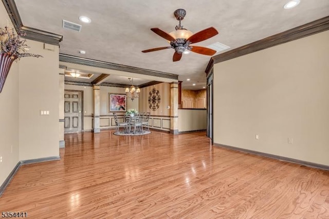 empty room with ornamental molding, a ceiling fan, light wood-style flooring, a chandelier, and baseboards