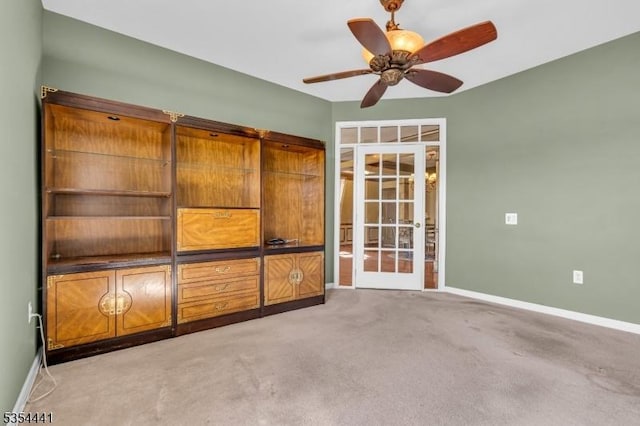 unfurnished bedroom with baseboards, carpet floors, and ceiling fan