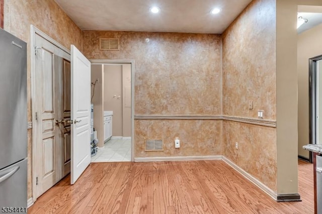 unfurnished room featuring light wood finished floors, recessed lighting, and baseboards