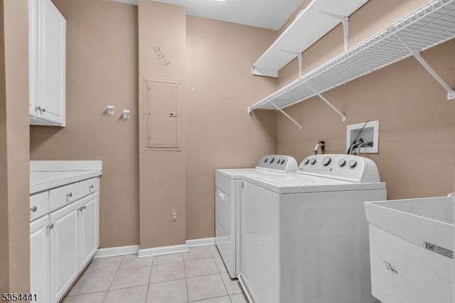laundry room with washing machine and dryer, cabinet space, baseboards, and light tile patterned floors