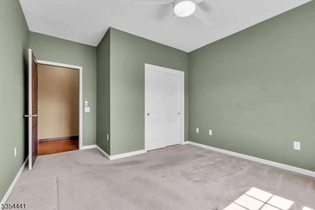 unfurnished bedroom with carpet floors, baseboards, ceiling fan, and a closet