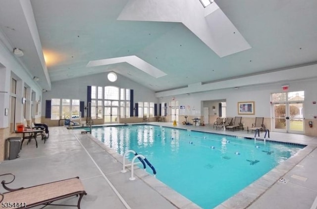 indoor community pool featuring a skylight