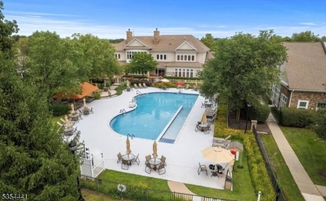 community pool with fence and a patio area