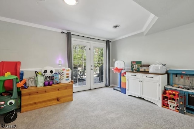 recreation room featuring french doors, carpet flooring, crown molding, and visible vents