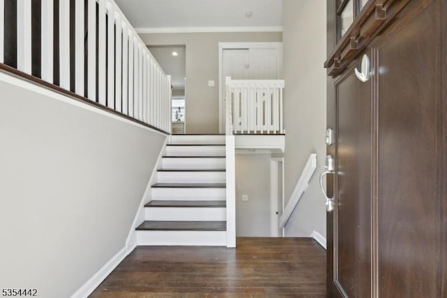 stairway featuring crown molding, baseboards, and wood finished floors