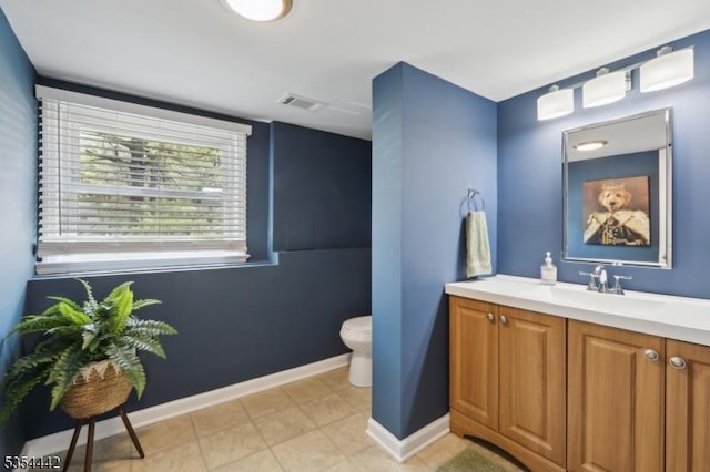 bathroom featuring vanity, baseboards, toilet, and visible vents