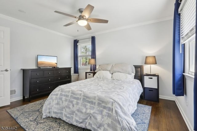 bedroom featuring ceiling fan, visible vents, crown molding, wood finished floors, and baseboards