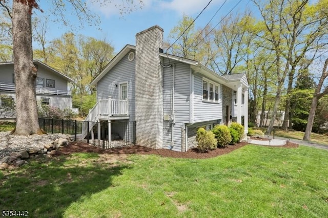 view of property exterior featuring a lawn, fence, and a chimney