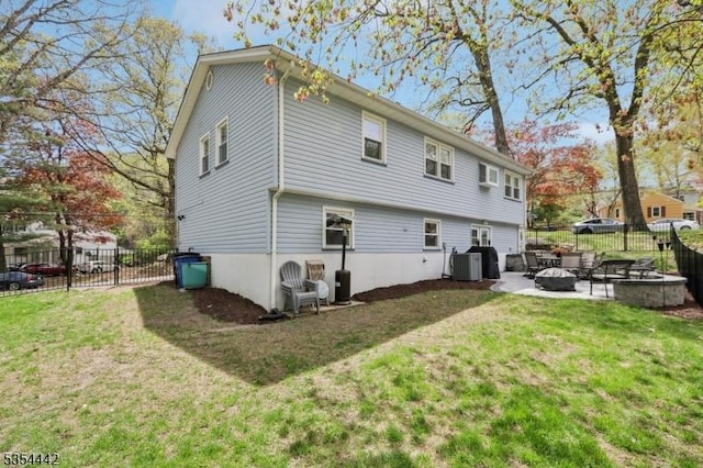 rear view of house featuring a lawn, fence, cooling unit, and a fire pit