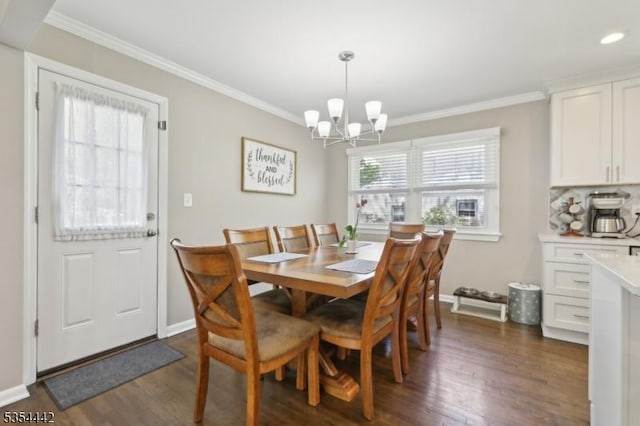 dining room with an inviting chandelier, ornamental molding, baseboards, and dark wood-type flooring
