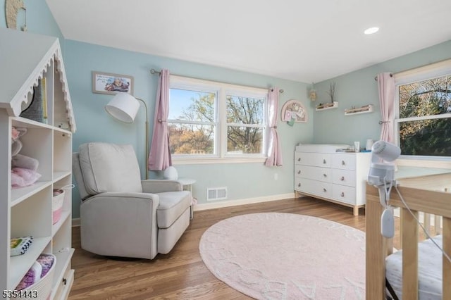 bedroom featuring wood finished floors, multiple windows, baseboards, and recessed lighting