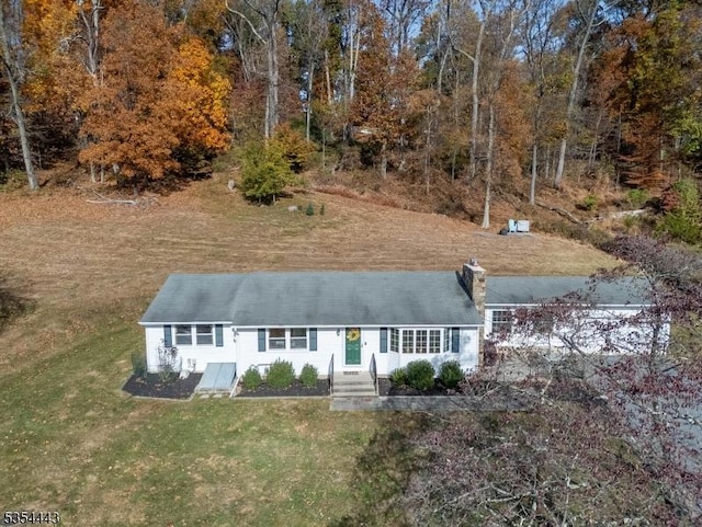 view of front facade featuring a front yard and a chimney