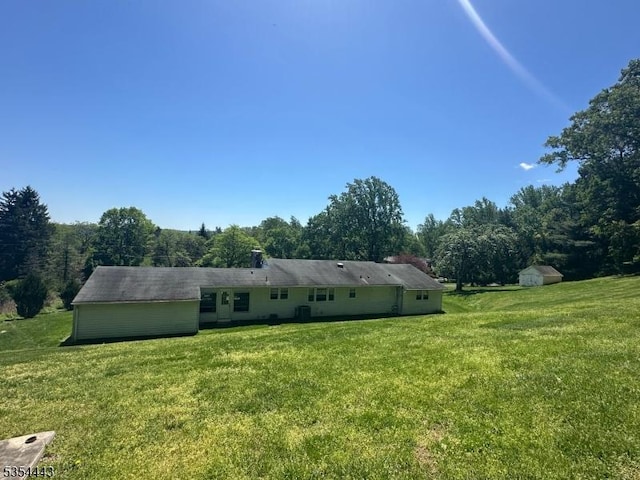 view of front of property with a front lawn, a storage shed, and an outdoor structure