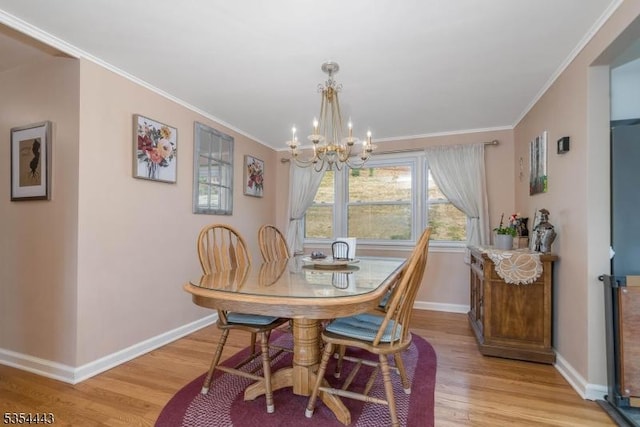 dining room with light wood-type flooring, a chandelier, baseboards, and crown molding